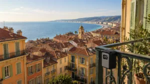Toits du Vieux-Nice et Baie des Anges au petit matin, boîte à clés de location saisonnière au premier plan — baromètre marché LCD Nice septembre 2026